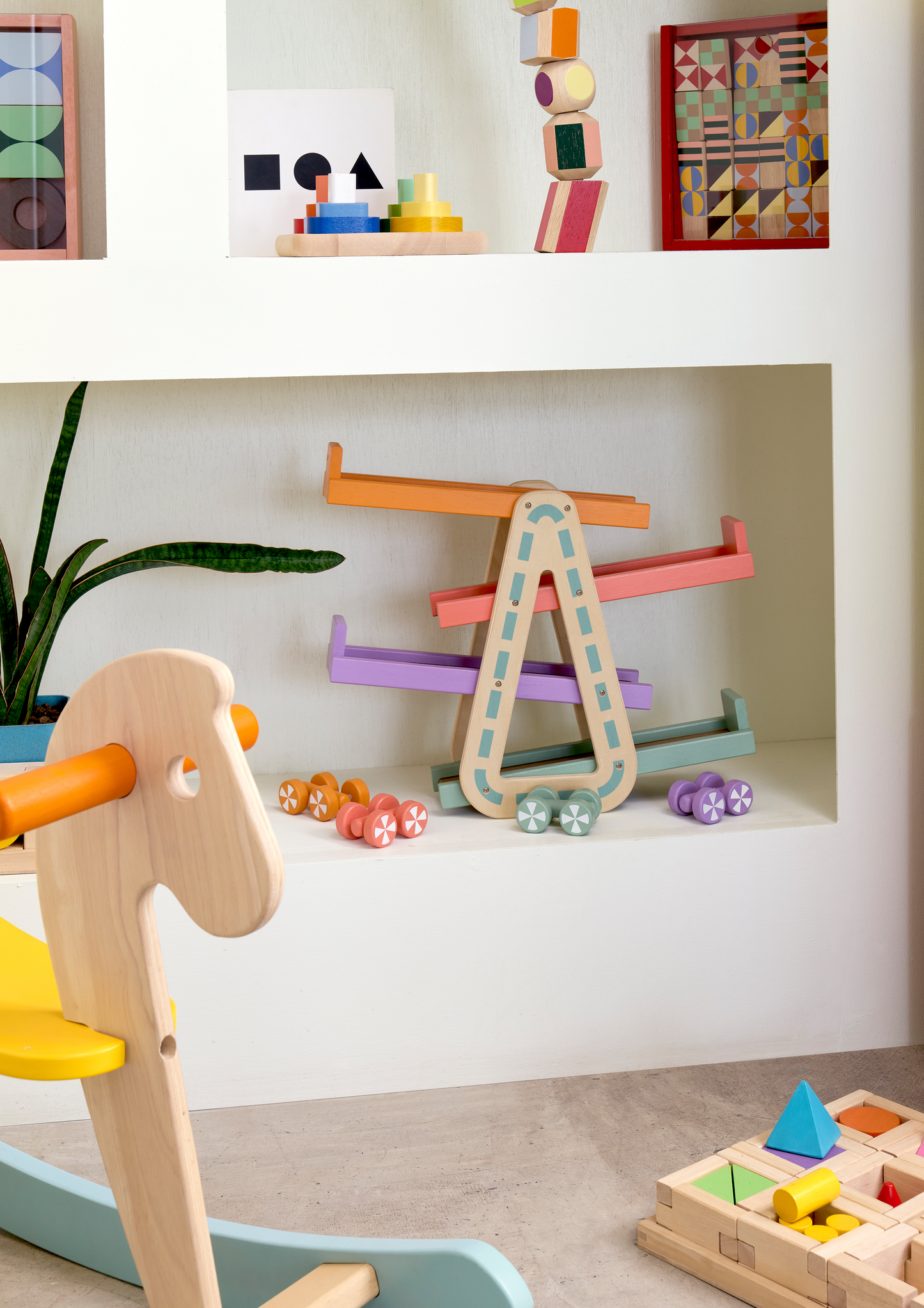 A colorful wooden racing toy set with four wooden racing cars and a triangular speed ramp.