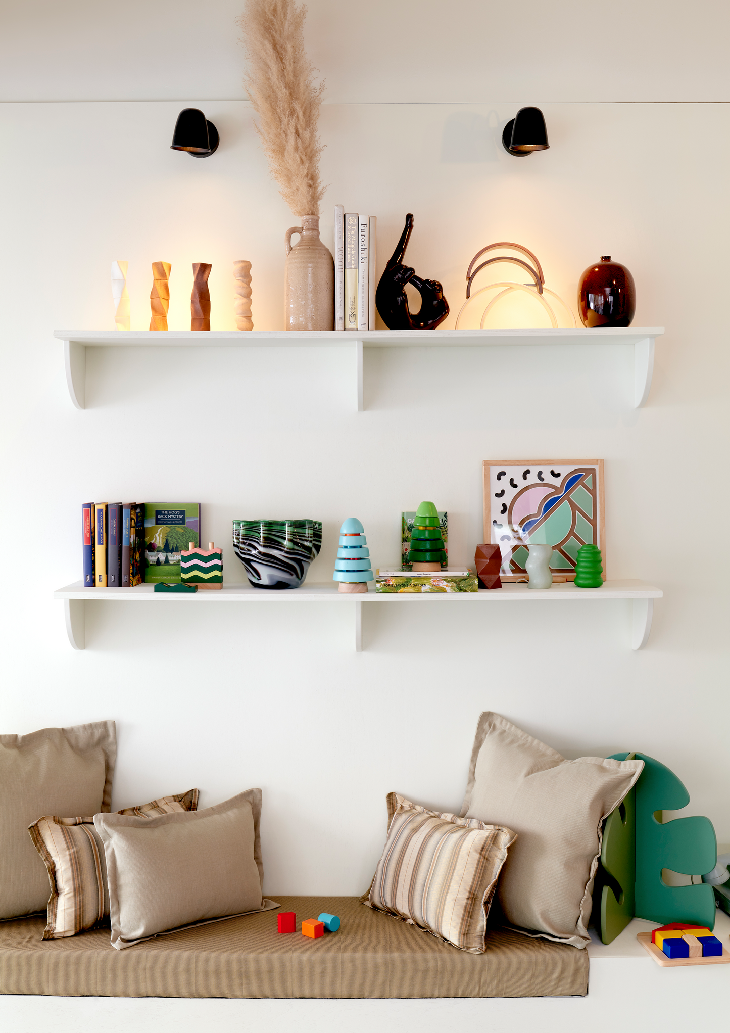 An educational toy consisting of a green block with a pattern of zigzag lines in green, orange, white, and yellow on its upper surface.