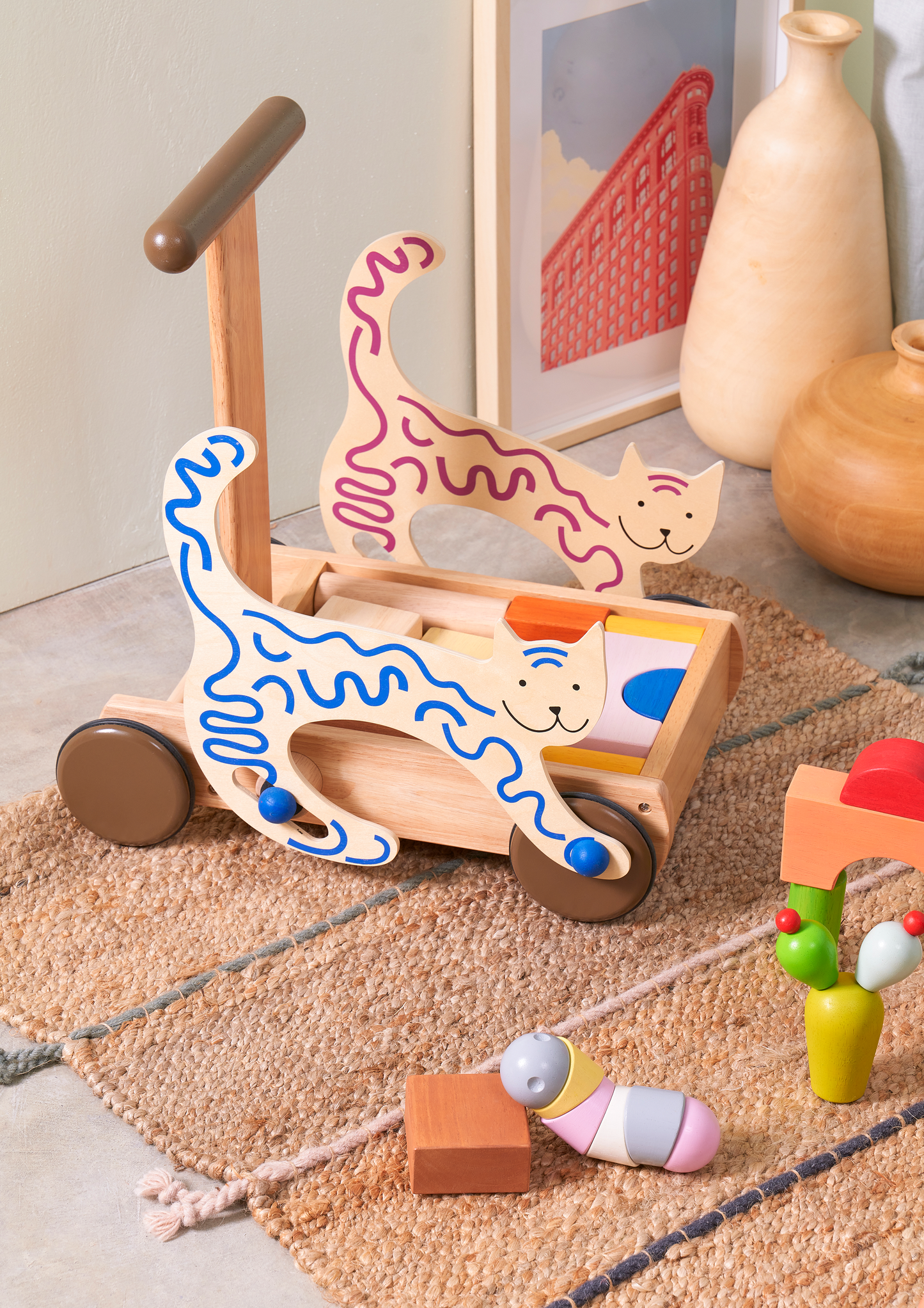 A wooden kitty walker toy with a cart and cat figures on wheels.