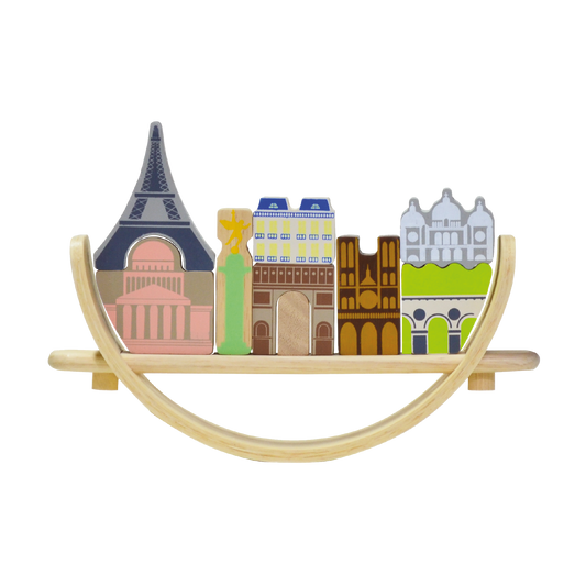 A wooden balancing toy set representing a Paris cityscape, with various colored pieces shaped as famous landmarks and a beige crescent base.