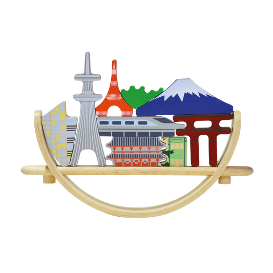 A balancing toy set inspired by the Tokyo cityscape, featuring various iconic landmarks placed on a crescent-shaped base which can rock when touched.